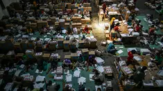 Sejumlah pekerja menyortir dan melipat surat suara untuk Pemilihan Umum (Pemilu) yang dijadwalkan digelar pada 14 Februari 2024 mendatang, di gudang KPU Surabaya, Jawa Timur, Kamis (21/12/2023). (Photo by Juni Kriswanto / AFP)