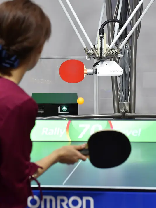 Seorang pria bertanding melawan robot Forpheus pada prapertunjukan di ajang CEATEC JAPAN 2017, Tokyo, Senin (2/10). Forpheus bisa menilai keterampilan manusia, hingga bisa memberikan tips untuk membantu meningkatkan teknik mereka. (Kazuhiro NOGI/AFP)