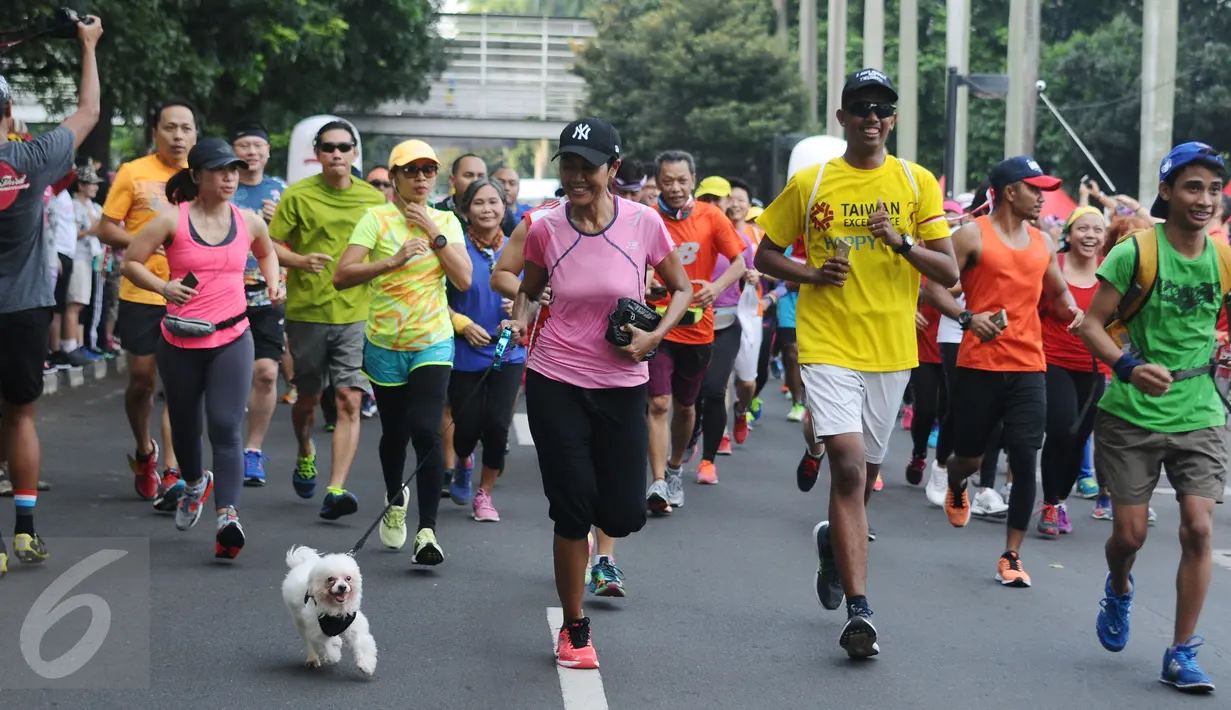 Peserta ToleRun 2016 membawa anjing saat berlari di kawasan Jalan Jend Sudirman, Jakarta, Minggu (20/11). Diikuti ratusan peserta, ToleRun 2016 dilaksanakan serentak di 31 kota di Indonesia. (Liputan6.com/Helmi Fithriansyah)