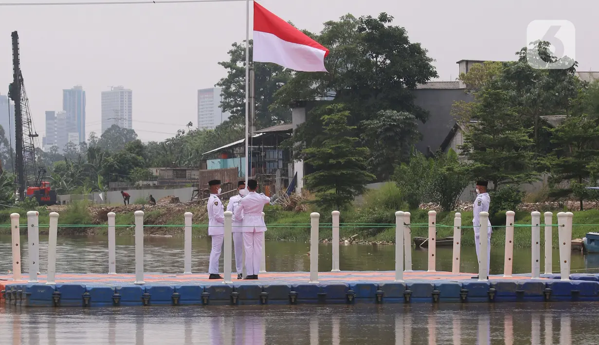 Anggota Paskibraka melakukan pengibaran bendera merah putih di Sungai Cisadane, Kota Tangerang, Banten, Kamis (28/10/2021). Pengibaran bendera merah putih yang di ikuti puluhan pemuda tersebut di lakukan untuk memperingati hari sumpah pemuda. (Liputan6.com/Angga Yuniar)