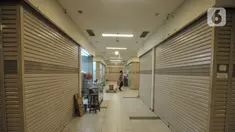 Pengunjung melintasi toko ritel yang tutup di salah satu pusat perbelanjaan kawasan Glodok, Jakarta, Senin (7/6/2021). Data Aprindo mencatat, sepanjang Maret 2020 hingga April 2021 sebanyak 1.250-1.300 toko ritel di Indonesia terpaksa tutup. (merdeka.com/Iqbal S. Nugroho)