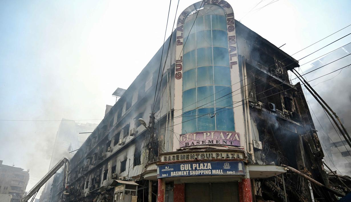 Petugas pemadam kebakaran dan tim SAR masih menyisir area gedung untuk memastikan tidak ada korban yang terjebak di bawah puing-puing. Tampak dalam foto, petugas pemadam kebakaran dan tim penyelamat melakukan operasi pendinginan di tengah puing-puing setelah kebakaran besar di sebuah pusat perbelanjaan di Karachi pada Senin 19 Januari 2026. (Asif HASSAN/AFP)