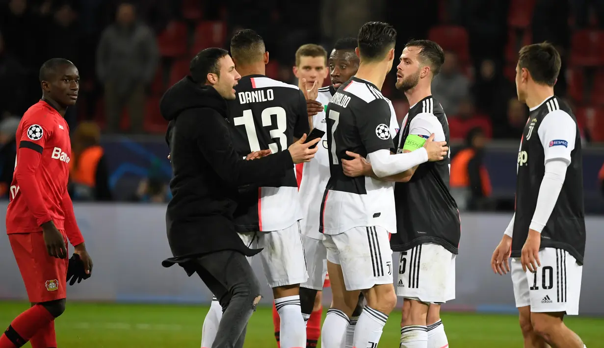Seorang penyusup (kedua kiri) mencoba mendekati Cristiano Ronaldo usai laga Liga Champions antara Juventus melawan Bayer Leverkusen di Bay Arena, Leverkusen, Jerman, Rabu (11/12/2019). (INA FASSBENDER/AFP)