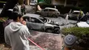 Serangan Iran tersebut menghantam area permukiman warga, menyebabkan kerusakan properti dan menghanguskan sejumlah kendaraan. Tampak dalam foto, warga dan pasukan keamanan Israel memeriksa lokasi yang terkena serangan rudal Iran di Petah Tikva, Israel, Selasa 31 Maret 2026. (AP Photo/Ohad Zwigenberg)