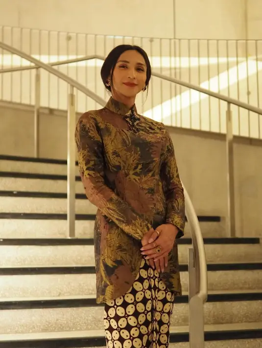 Melengkapi outfit khas Jeng Yah, Dena menggunakan bros dan anting bernuansa hitam dan emas [@denarachman]