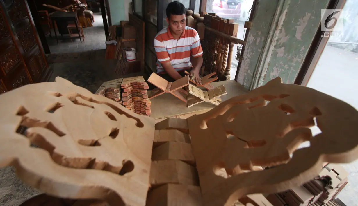 Pekerja menghaluskan kayu yang akan dibuat rekal Al Quran atau tatakan untuk Al Quran di kawasan Klender, Jakarta, Senin (5/6). Rekal Al Quran ini dijual dengan kisaran harga Rp20 ribu sampai Rp200 ribu. (Liputan6.com/Angga Yuniar)