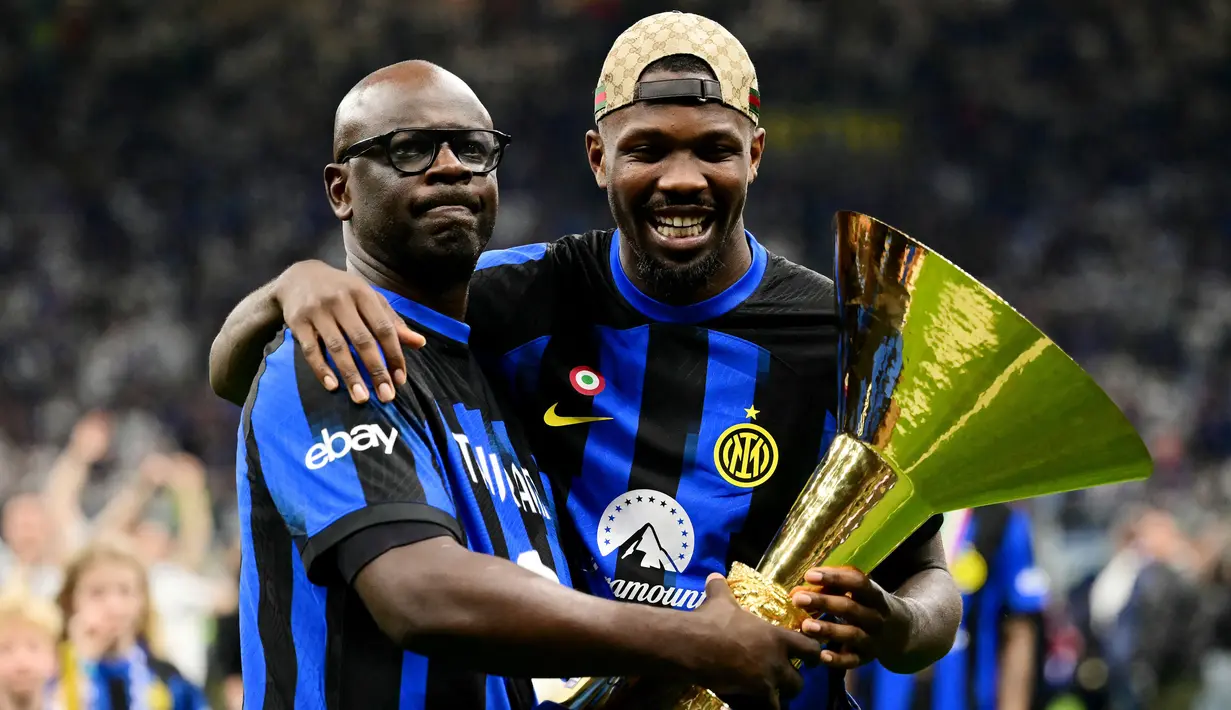 Pemain Inter Milan, Marcus Thuram, merayakan gelar juara Serie A bersama sang ayah yang juga seorang legenda Juventus di Stadion Giuseppe Meazza, (19/5/2024). (AFP/Marco Bertorello)