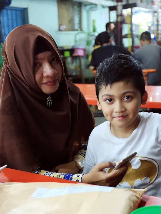 Ima ibu rumah tangga mengaku kesal lantaran hotel penuh hingga tanggal 27. Perempuan asli Medan yang kini sebagai pendatang itu mengaku rumah orangtua sudah penuh. Disisi lain, ia mengaku senang. (Deki Prayoga/Bintang.com)