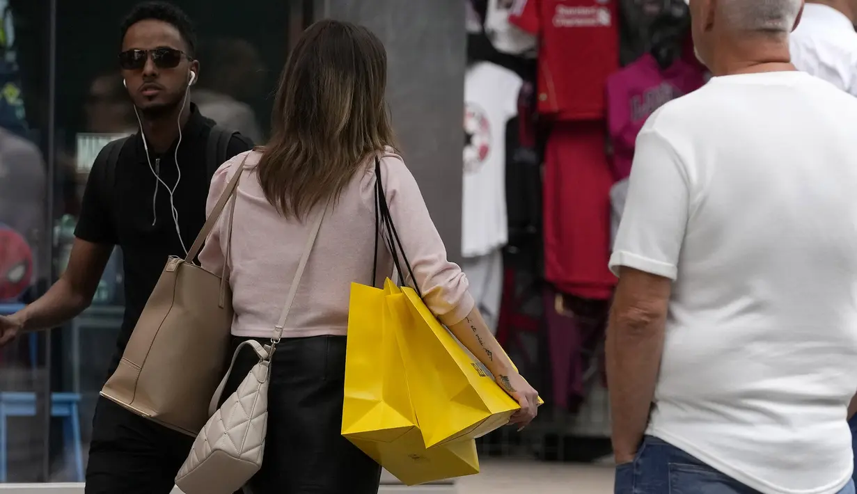 Seorang pembelanja membawa tas di London, Rabu (17/8/2022). Office for National Statistic (ONS) menyebut lonjakan harga pangan sebesar 12,7 persen sejak Juli 2021 menjadi penyumbang lonjakan inflasi Juli 2022. Sementara, bulan sebelumnya, inflasi Inggris berada di kisaran 9,4 persen. (AP Photo/Frank Augstein)