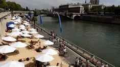 Bantaran Sungai Seine disulap menjadi pantai buatan lengkap dengan pasir dan bangku santai, Perancis, Rabu (22/7/2015).  Tahun ini adalah edisi ke-14 dari Paris Plages, acara budaya dan wisata utama di Paris selama musim panas. (AFP Photo/Miguel Medina)