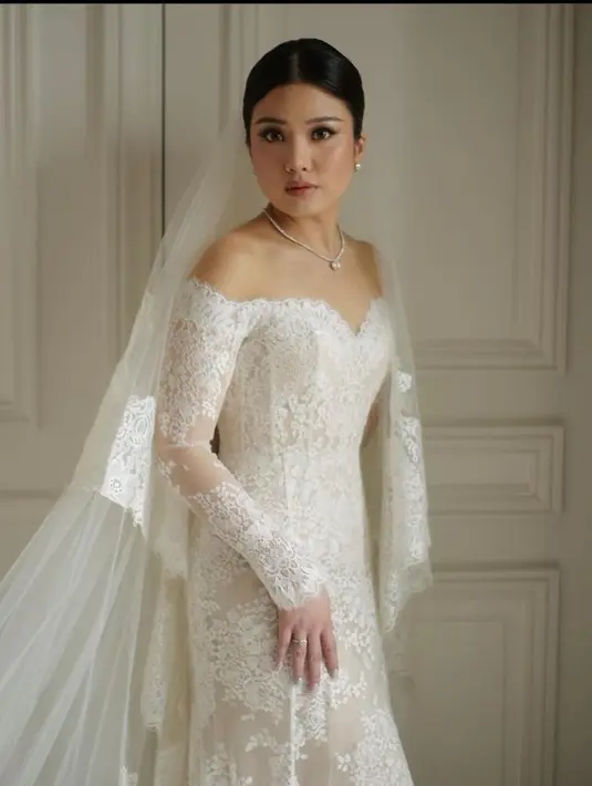 <p>Valencia Tanoe tampil elegan dalam balutan gaun klasik warna putih dan veil menjuntai saat pemberkatan nikah. [Foto: IG/morden.co].</p>