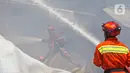 Petugas pemadam kebakaran memadamkan api yang membakar gudang alat pesta di kawasan Cinangka, Depok, Senin (2/8/2021). Banyaknya bahan dari kayu serta bahan yang mudah terbakar, membuat api dengan cepat menyambar dan menghanguskan isi dan bangunan gudang. (Liputan6.com/Herman Zakharia)