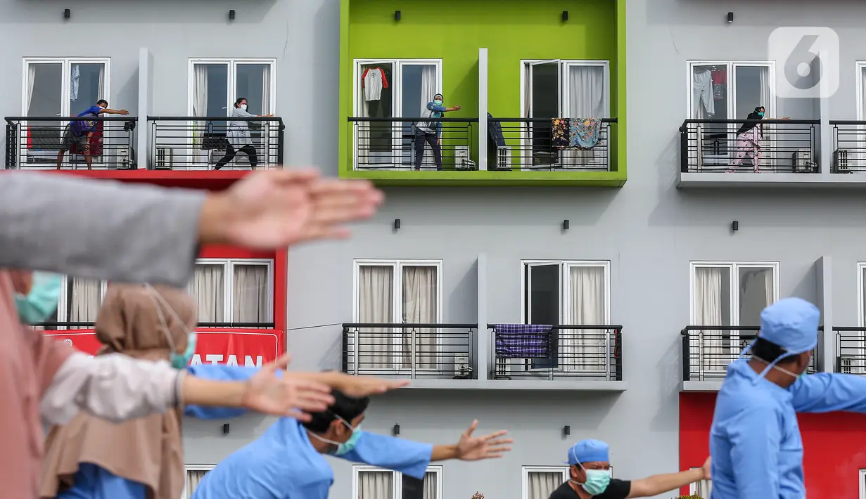 Pasien orang tanpa gejala (OTG) Covid-19 mengikuti senam pagi bersama tenaga medis dari atas balkon di Rumah Singgah Karantina Covid-19 Kabupaten Tangerang, Selasa (26/5/2020). Senam pagi yang diikuti 40 OTG berlangsung sekitar 30 menit mulai pukul 08.00 WIB. (Liputan6.com/Fery Pradolo)
