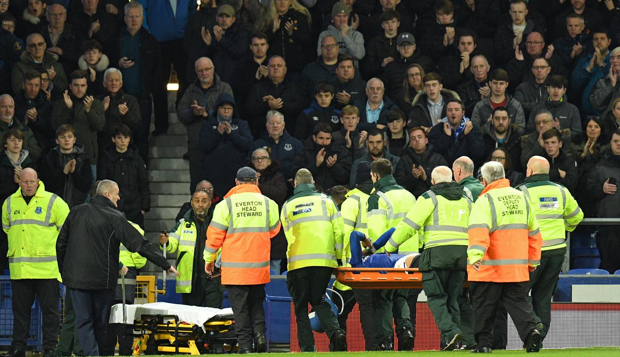 Gelandang Everton, Andre Gomes, dibawa keluar lapangan usai mengalami cedera usai dilanggar oleh penyerang Tottenham Hotspur, Son Heung-min, pada laga Premier League di Goodison Park, Minggu (3/11). Tekel tersebut menyebabkan Gomes mengalami patah kaki. (AFP/Oli Scarff)