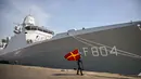 Personel Tentara Nasional Indonesia (TNI) Angkatan Laut (AL) membawa bendera sinyal maritim internasional berjalan di samping kapal perang Kerajaan Belanda HNLMS De Ruyter di pelabuhan Tanjung Perak, Surabaya, Jawa Timur pada Kamis 14 Mei 2026. (JUNI KRISWANTO/AFP)