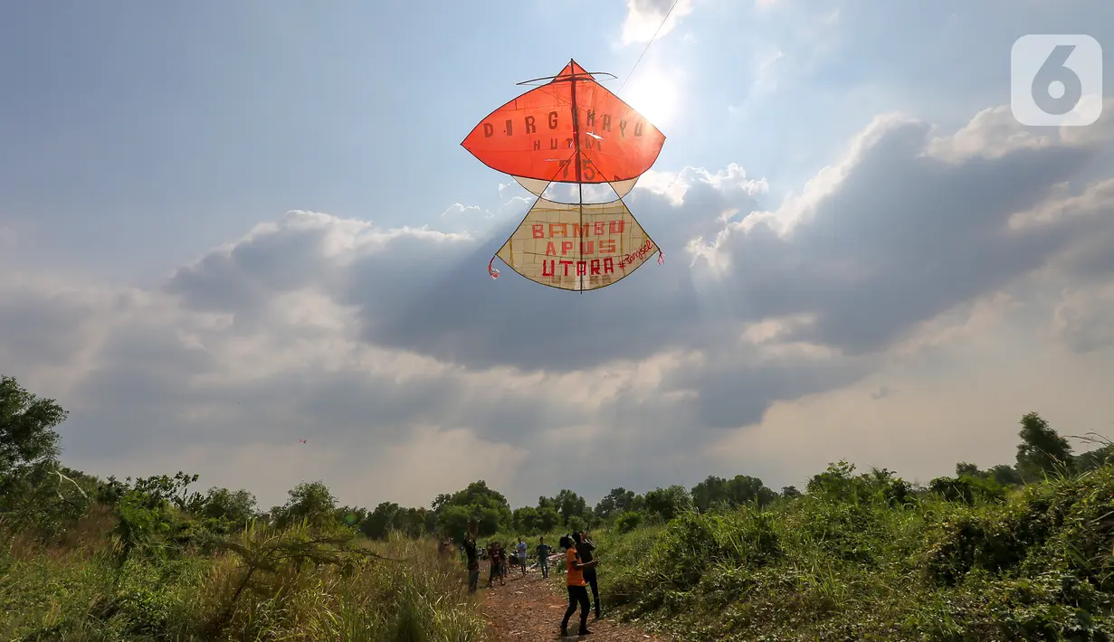 Sebuah layang-layang merah putih raksasa terbang diatas langit di kawasan Bambu Apus, Tangerang Selatan, Senin (17/8/2020). Layangan berukuran 10 X 9 meter yang ditarik menggunakan tambang diterbangkan dalam rangka memperingati HUT Ke-75 RI. (Liputan6.com/Fery Pradolo)