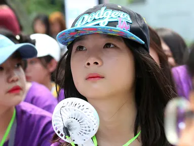 Seorang siswa memegang kipas portabel saat berunjuk rasa di Kedutaan Besar Jepang di Seoul, Korea Selatan, Rabu (1/8). Badan Meteorologi Korea Selatan mengeluarkan peringatan gelombang panas untuk Seoul dan kota-kota lainnya. (AP Photo/Ahn Young-joon)