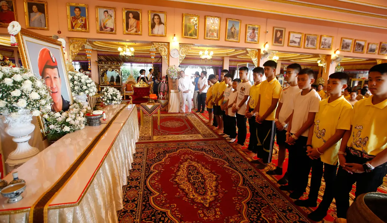 Anggota tim sepak bola Thailand berdoa untuk pensiunan penyelam SEAL yang meninggal dalam upaya penyelamatan mereka dari galam gua, Distrik Mae Sai, Provinsi Chiang Rai, Kamis (19/7). (AP Photo/Sakchai Lalit)