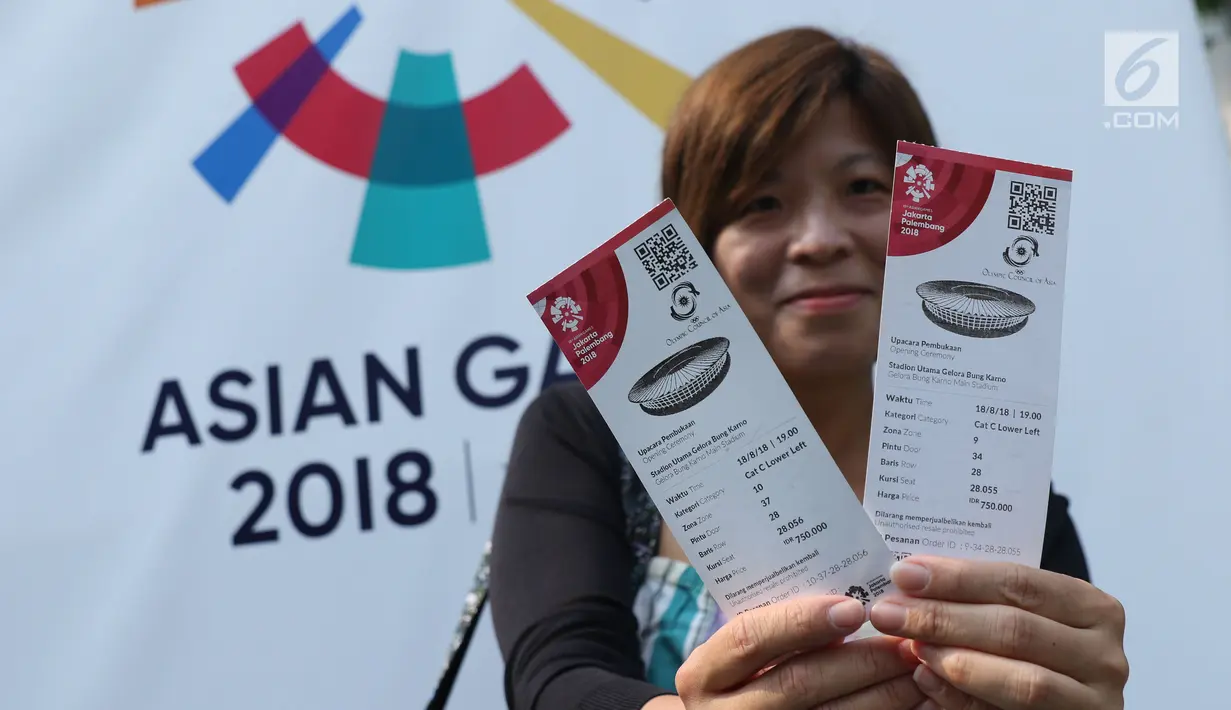 Salah satu calon penonton seremoni pembukaan Asian Games 2018 menunjukkan tiketnya jelang masuk kawasan GBK, Jakarta, Sabtu (18/8). Asian Games 2018 akan berlangsung hingga 2 September, mendatang. (Liputan6.com/Helmi Fithriansyah)