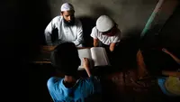 Seorang anak serius membaca Al-Quran saat di sebuah madrasah lokal selama bulan Ramadan di Srinagar, Kashmir yang dikuasai India, (30/5). Di bulan puasa umat muslim menahan diri untuk tidak makan dan minum. (AP Photo / Mukhtar Khan)