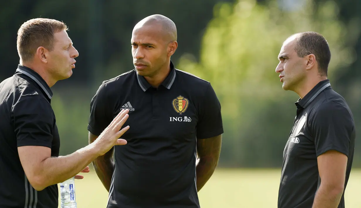 Asisten pelatih Belgia, Thierry Henry  (tengah) berbincang dengan asisten pelatih Graeme Jones (kiri)  dan Pelatih Kepala Roberto Martinez (kanan) pada sesi latihan sebelum melawan Spanyol di Neerpede, (29/8/2016). (AFP/John Thys)