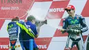 Jorge Lorenzo menyemprotkan sampanye ke arah manajer tim Yamaha, Lin Jarvis, dan Valentino Rossi. (AP Photo/Vincent Jannink) 