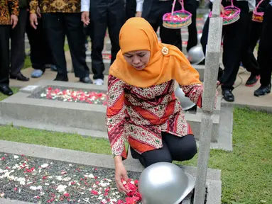 Menteri Sosial Khofifah Indar Parawansa menaburkan bunga di salah satu makam pahlawan di Taman Makam Pahlawan Kalibata, Jakarta, Senin (2/10). Mensos mengajak 50 santri penghafal Alquran untuk mendoakan para pahlawan nasional. (Liputan6.com/Faizal Fanani)