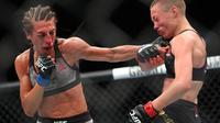 Joanna Jedrzejczyk (kiri) melayangkan pukulan tangan kiri ke wajah lawannya Rose Namajunas pada kejuaraan UFC 223 kelas strawweight di Barclays Center, New York, 7 April 2018. (Ed Mulholland/Getty Images/AFP)