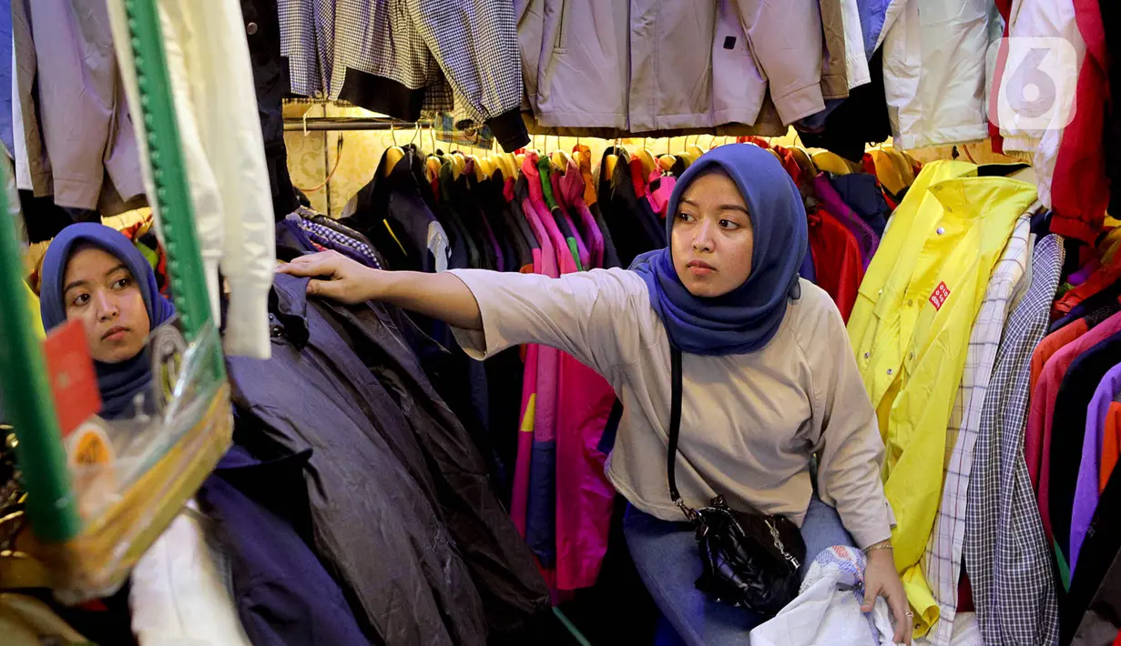 Seorang calon pembeli memilih pakaian impor bekas di Pasar Senen, Jakarta, Kamis (9/3/2023). Larangan impor baju bekas bertujuan untuk mendukung penggunaan produk lokal dan usaha kecil dan menengah milik masyarakat Indonesia. (Liputan6.com/Faizal Fanani)