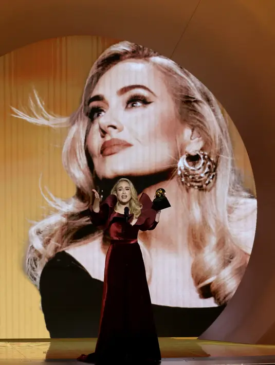 Adele saat menerima penghargaan Best Pop Solo Performance untuk lagu "Easy On Me," di atas panggung selama Grammy Awards 2023 di Crypto.com Arena di Los Angeles, California pada 5 Februari 2023. The Rock, yang juga dikenal sebagai aktor, didatangkan khusus ke Grammy 2023 untuk Adele. (Frazer Harrison/Getty Images/AFP)