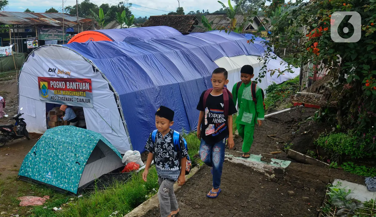 Murid-murid korban gempa belajar usai sekolah pada tenda di halaman sekolah di SDN Gintung, Mangunkerta, Cianjur, Jumat (23/12/2022). Lebih dari sebulan sejak musibah gempa bumi 5,2 SR sejumlah murid sekolah di Cianjur masih belajar pada tenda darurat. (merdeka.com/Arie Basuki)