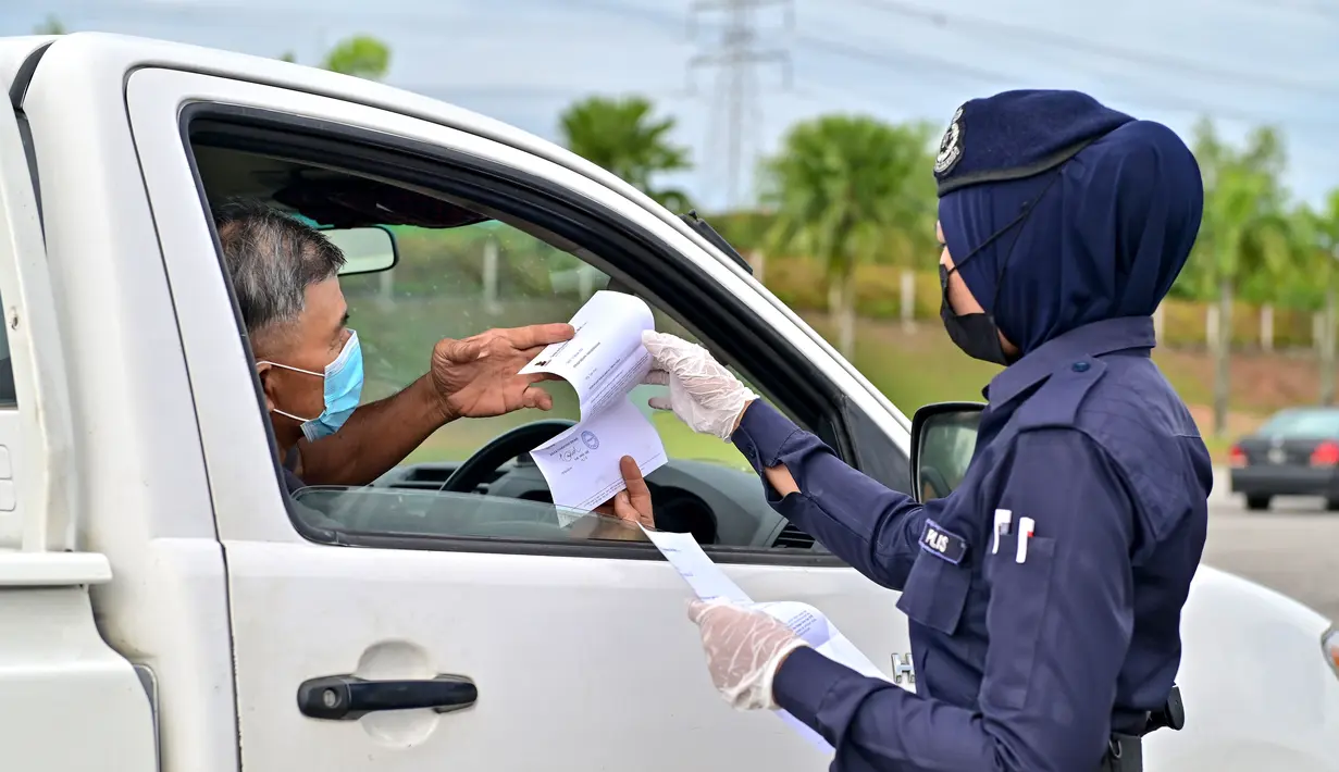 Polisi memeriksa kendaraan yang melintas di pos pemeriksaan jalan tol Setia Alam di Negara Bagian Selangor 5 Desember 2020. Pemerintah Malaysia akan memperpanjang perintah kontrol pergerakan orang di beberapa area hingga 20 Desember untuk mengendalikan penyebaran COVID-19. (Xinhua/Chong Voon Chung)