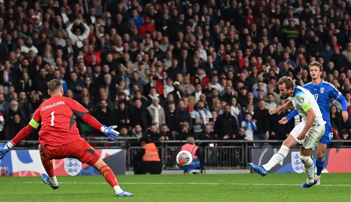 Pemain Timnas Inggris, Harry Kane (tengah), menendang bola ke gawang Timnas Italia yang membuahkan gol dalam laga lanjutan Kualifikasi Euro 2024 yang digelar di Wembley, London pada Rabu (18/10/2023) dini hari WIB. Harry Kane mencetak dua gol dalam kemenangan 3-1 Timnas Inggris atas Timnas Italia. (AFP/Glyn Kirk)