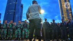 Personel gabungan TNI-Polri saat apel persiapan pengamanan perayaan malam Tahun Baru 2023 di Bundaran HI, Jakarta, Sabtu (31/12/2022). Petugas juga telah melakukan sterilisasi di kawasan Bundaran HI pada pukul 18.00 WIB dan ditutup secara permanen pada pukul 20.00 WIB. (Liputan6.com/Angga Yuniar)