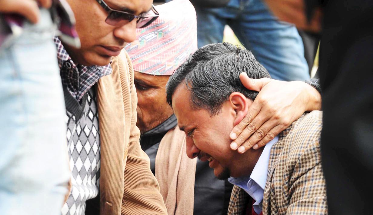 Seorang kerabat salah satu penumpang Twin Otter menangis setelah mengetahui kabar jatuhnya pesawat yang dioperasikan maskapai Tara Air itu, di bandara di Pokhara, Nepal, Rabu (24/2). (REUTERS/Krishna Mani Baral)