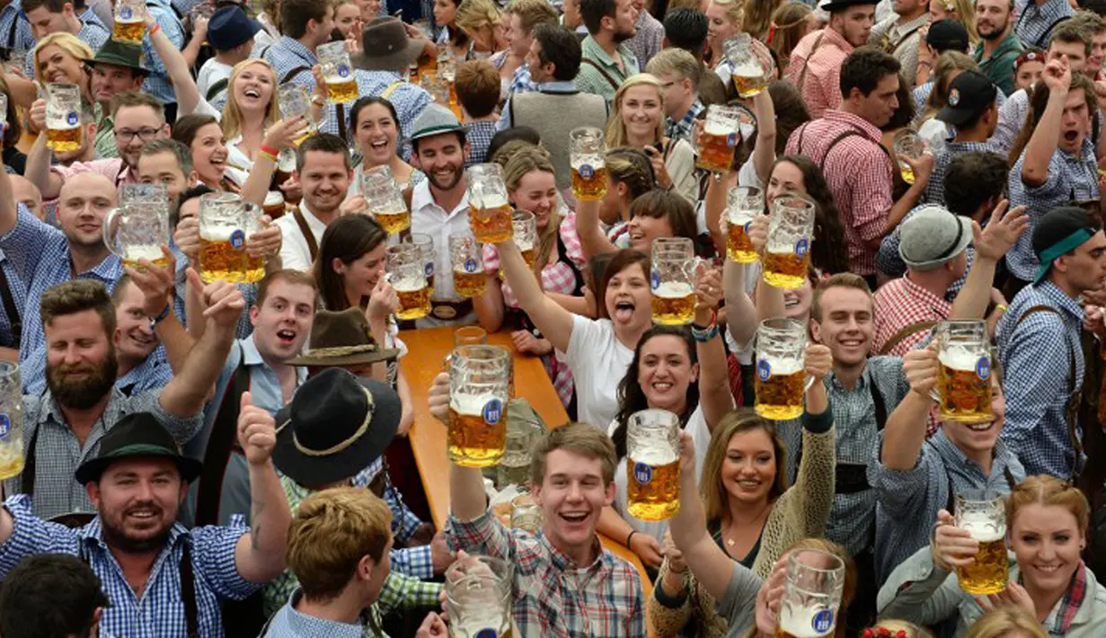Pengunjung Festival Bir Oktoberfest berpose usai pembukaan festival di Munich, Jerman (19/9/2015). Oktoberfest di Jerman adalah festival bir terbesar di dunia yang akan berlangsung hingga 4 Oktober 2015. (AFP Photo / Christof stache) 