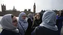 Puluhan perempuan dari beragam etnis berkumpul menggelar aksi solidaritas mengenang korban teror London di Jembatan Westminster, dekat Gedung Parlemen Inggris, Minggu (26/3). Aksi solidaritas dihelat oleh Women’s March di London. (Daniel LEAL-OLIVAS/AFP)