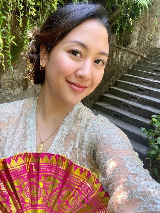 Berada di Bali, Sherina memilih mengenakan kebaya brokat putih. Dengan riasan wajah natural hanya tampak lipstik nude. [@sherinamunaf]