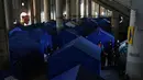 Langkah darurat ini diambil menyusul eskalasi konflik antara Israel dan Hizbullah yang pecah kembali sejak Maret 2026. Tampak dalam foto, para pengungsi berdiri di samping tenda-tenda yang didirikan di dalam Camille Chamoun Sports City Stadium, yang telah diubah menjadi tempat penampungan bagi orang-orang yang melarikan diri dari serangan udara Israel di Lebanon selatan, Beirut, Lebanon, Rabu 8 April 2026. (AP Photo/Bilal Hussein)