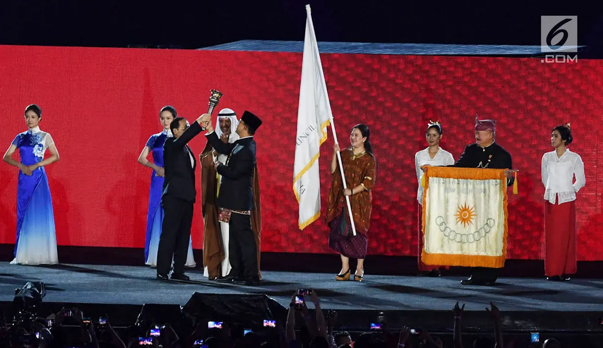 Gubernur DKI Jakarta Anies Baswedan menyerahkan obor Asian Games kepada Wali Kota Hangzhou China saat penutupan Asian Games 2018 di Stadion Utama GBK, Jakarta, Minggu (2/9). (Merdeka.com/Imam Buhori)