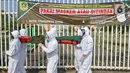 Petugas Satpol PP Kabupaten Bogor yang mengenakan pakaian hazmat menggotong warga pelanggar PSBB di kawasan Stadion Pakansari, Kabupaten Bogor, Jawa Barat, Minggu (6/9/2020). Pemkab Bogor menerapkan sanksi denda Rp 100 ribu serta sanksi sosial bagi pelanggar PSBB. (Liputan6.com/Herman Zakharia)