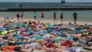 Ribuan orang terbaring diatas pasir untuk membuat "Sand Angels" di Pantai Stearns Park, Ludington (10/6). Sebanyak 1.414 orang ikut berpatisipasi untuk memecahkan rekor Malaikat Pasir terbanyak di dunia. (Joel Bissell / Muskegon Chronicle via AP)