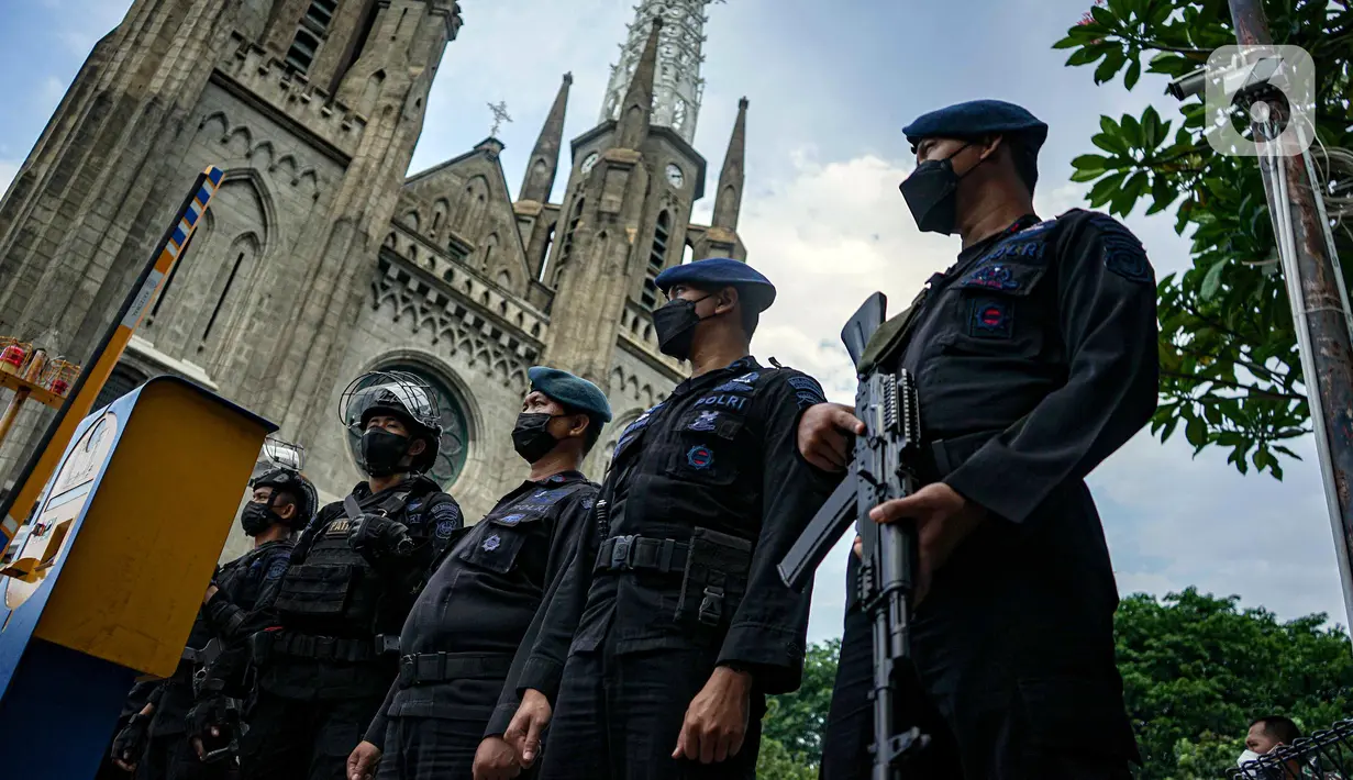 Personel Brimob melakukan penjagaan saat penyisiran di Gereja Katedral, Jakarta, Jumat (24/12/2021). Polda Metro Jaya bersama Satuan Brimob melakukan sterilisasi sejumlah gereja guna memastikan bebas dari bahan berbahaya. (Liputan6.com/Faizal Fanani)