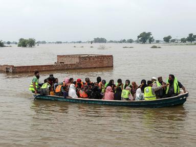 Relawan mengevakuasi warga desa yang terdampak banjir dengan perahu di Jalalpur Pirwala, distrik Multan, provinsi Punjab, pada 8 September 2025. (Shahid Saeed MIRZA/AFP)