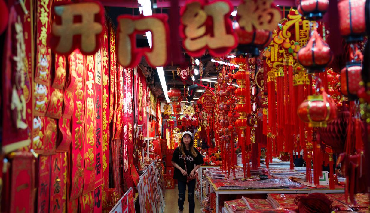 Bagi masyarakat Tiongkok, perayaan Tahun Baru Imlek dilambangkan dengan ajang reuni keluarga, bentuk rasa syukur, dan harapan keberuntungan untuk tahun berikutnya. Tampak dalam foto, seorang pembeli berjalan melewati pasar yang dipenuhi dekorasi Tahun Baru Imlek berwarna merah di Beijing, China, Rabu 4 Februari 2026. (AP Photo/Vincent Thian)