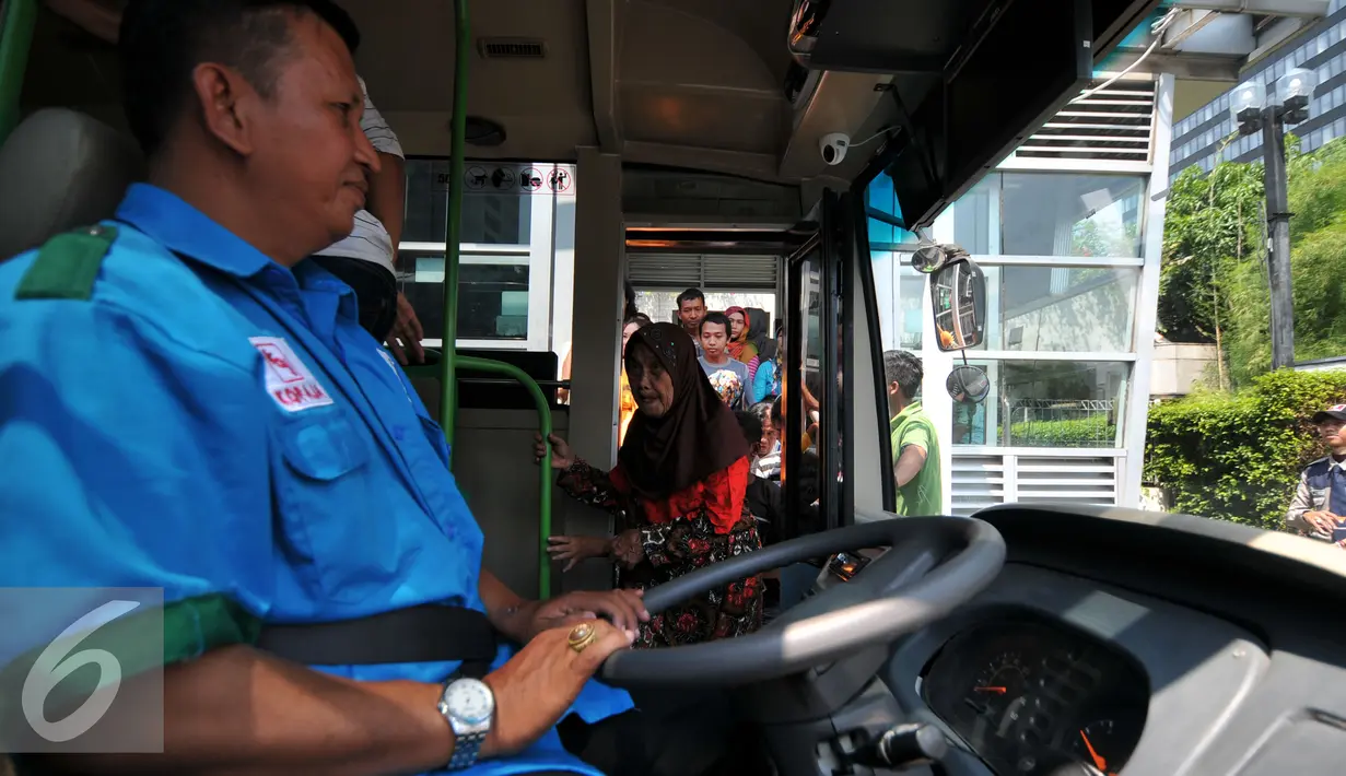 Penumpang  saat menaiki bus Transjakarta menuju Ragunan di Halte Dukuh Atas 2, Jakarta, Jumat (1/1/2016). Ratusan penumpang menumpuk menunggu bus TransJakarta tujuan Ragunan untuk menikmati libur panjang 2016. (Liputan6.com/Yoppy Renato)