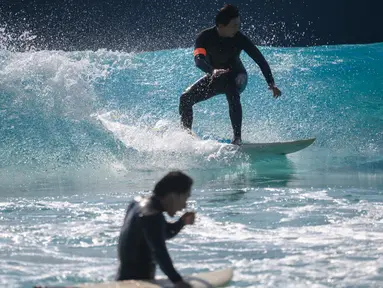 Peselancar meniti ombak di kolam ombak Wave Park di Siheung, Korea Selatan pada 18 Oktober 2020. Korea Selatan memiliki kolam ombak terbesar di dunia dengan teknologi Wavegarden Cove yang memiliki beberapa modul produksi gelombang dan menjadi kolam gelombang dengan jumlah terbesar. (Ed JONES/AFP)