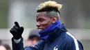 Gelandang timnas Prancis Paul Pogba menyapa penggemar sebelum mengikuti sesi latihan di Clairefontaine-en-Yvelines, Paris (19/3). (AFP Photo/Franck Fife)