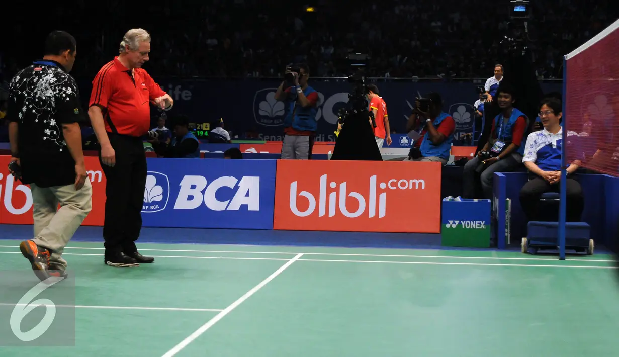 Petugas BWF melihat durasi waktu penghentian laga Jonatan Christie melawan Hsu Jen Hao di penyisihan BCA Indonesia Open 2016, Istora Senayan Jakarta, Rabu (1/6/2016). Laga sempat dihentikan akibat atap Istora bocor. (Liputan6.com/Helmi Fithriansyah)