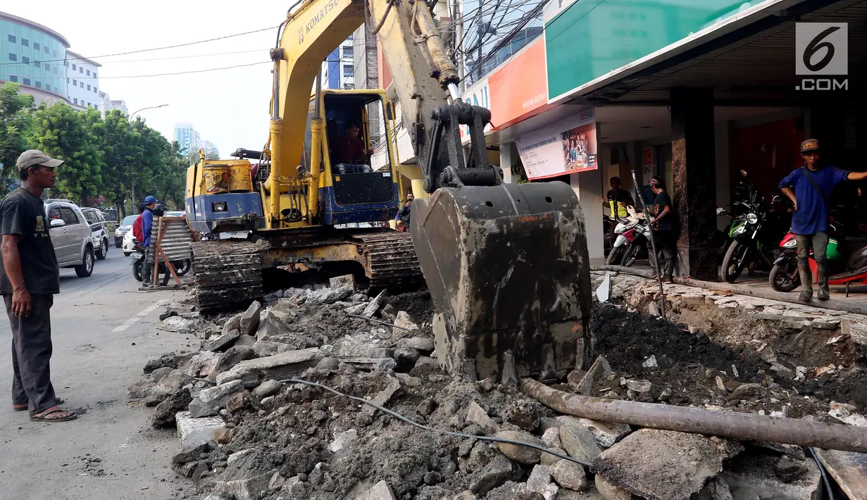 Alat berat membongkar saluran air (drainase) yang akan diperbaiki di jalan Hayam Wuruk, Jakarta Pusat, Selasa (20/11). Perbaikan dan pelebaran saluran air ini untuk mengantisipasi terjadinya banjir di kawasan tersebut saat hujan (Liputan6.com/Johan Tallo)